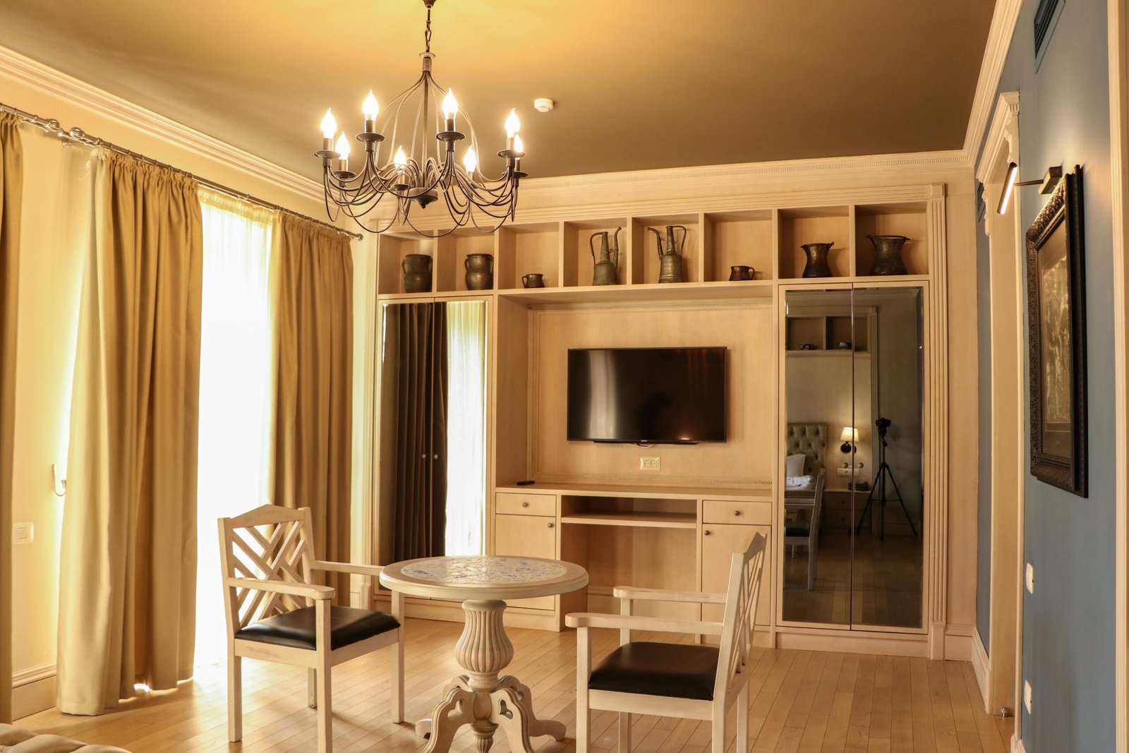 Classic interior design of a living room in Baku, Azerbaijan, featuring a chandelier, elegant furniture, and natural light.